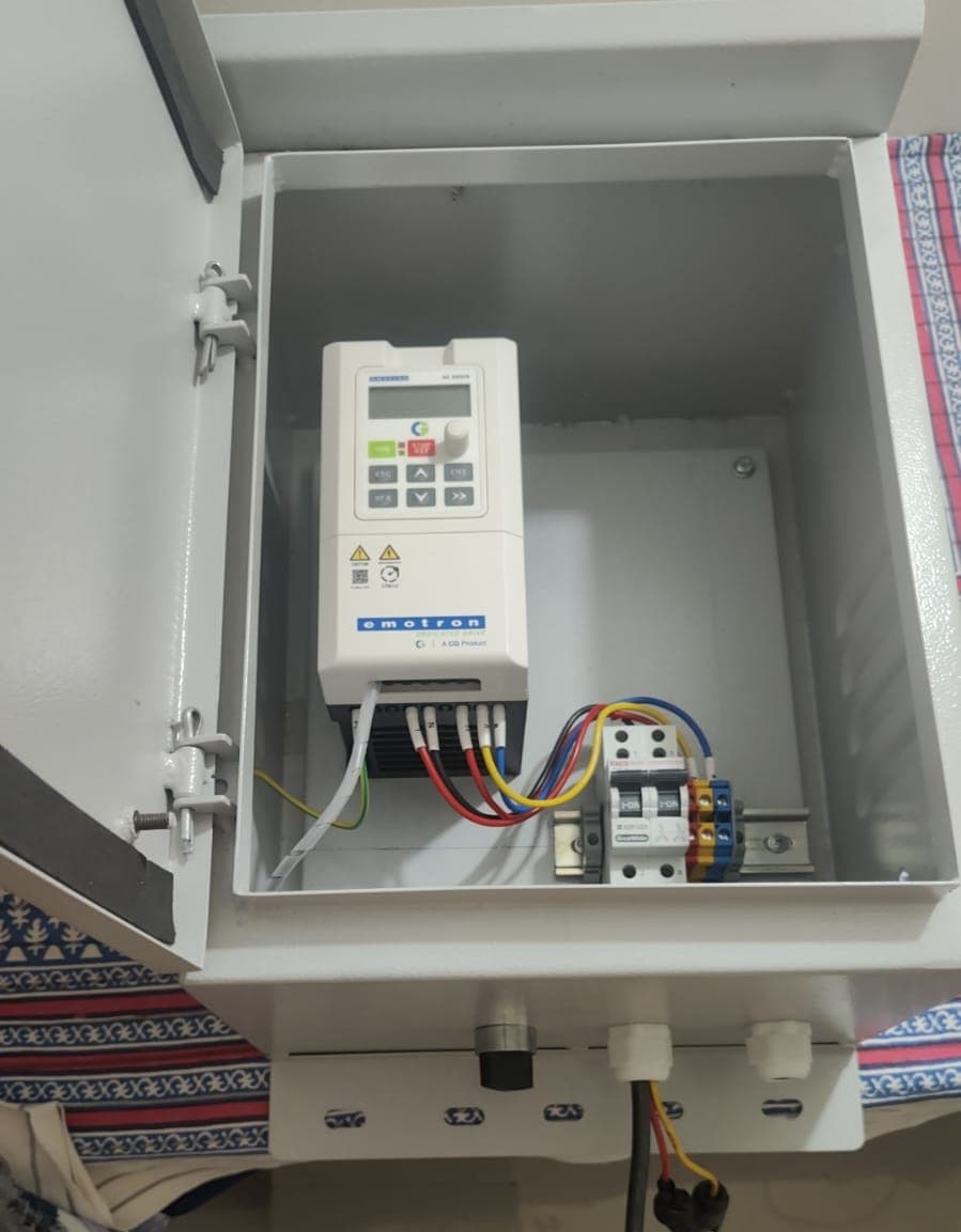 Emotron drive wired into a wall-mounted enclosure with breaker and terminal rail