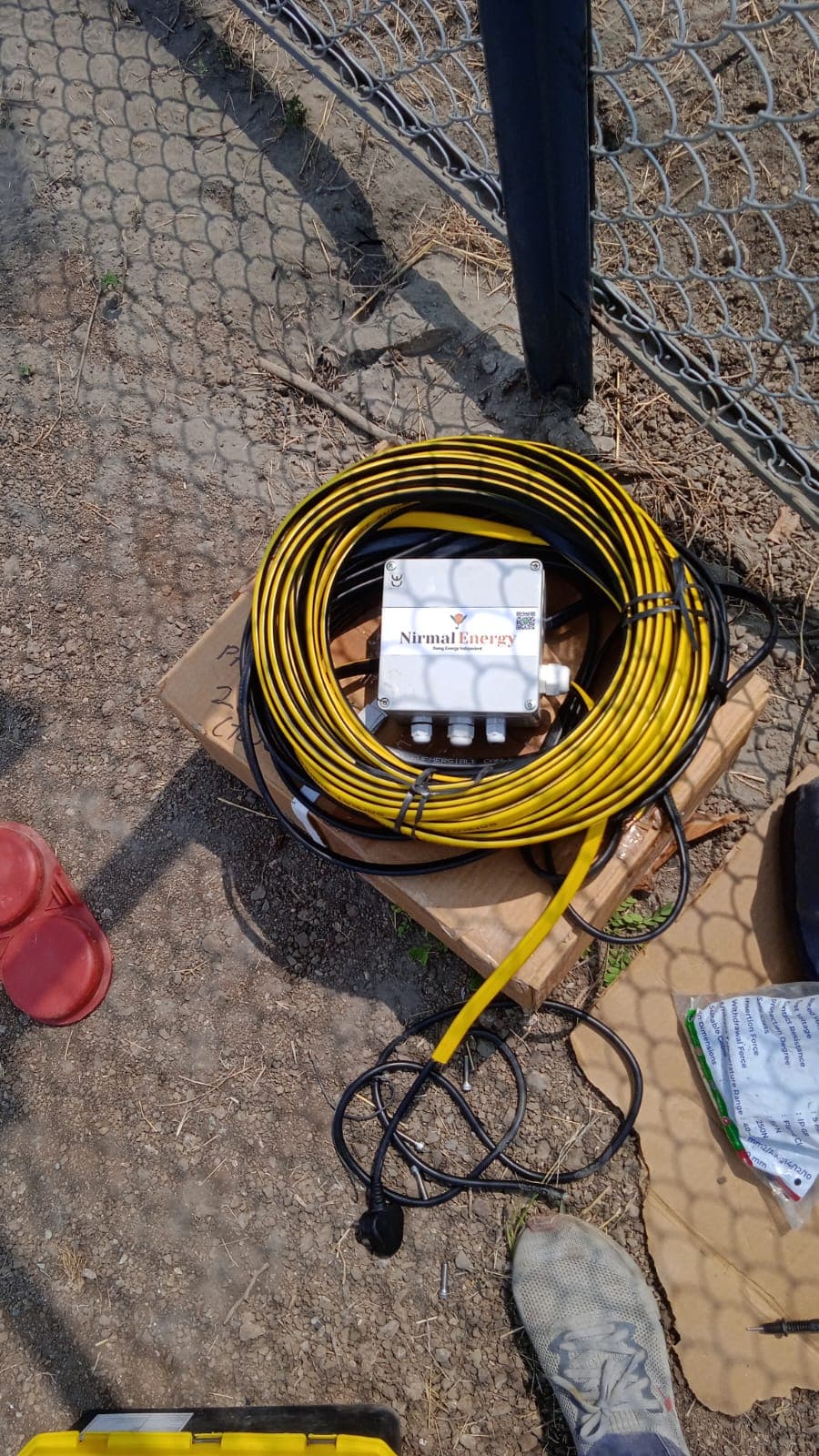 Coiled submersible pump cable and a branded junction box laid out on site before installation